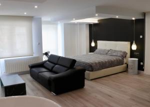 una camera con letto, divano e sedia di Black and White Suitte "Plaza" a Noja