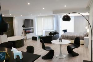 sala de estar con cama, mesa y sillas en Black and White Suitte "Plaza", en Noja