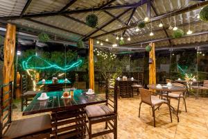a dining area with tables and chairs and a ping at Aldea Real Eco Friendly in Baños