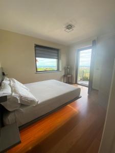 sypialnia z łóżkiem i dużym oknem w obiekcie Casa Arge w mieście La Morra