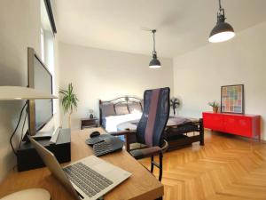 Zimmer mit einem Schreibtisch, einem Laptop und einem Bett in der Unterkunft 4 bedroom apartment in city center with air conditioning in Bratislava