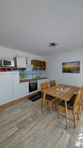 kuchnia z drewnianym stołem i krzesłami w pokoju w obiekcie Ferienwohnung Seestern im Haus-Neuharlingersiel w mieście Neuharlingersiel
