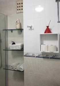 dos fotos de un baño con toallas en estanterías en Departamento frente al Mar - Kiara en Cancún