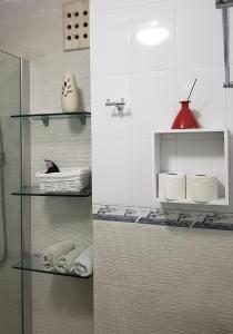two pictures of a bathroom with towels on shelves at Departamento frente al Mar - Kiara in Canc&uacute;n