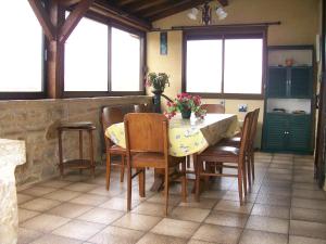 una sala da pranzo con tavolo, sedie e finestre di Gîte "L'helpe" dans grande maison quercynoise entre Sarlat Rocamadour a Gourdon en Quercy