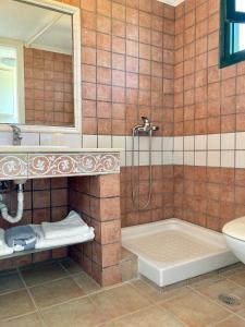 een badkamer met een bad, een wastafel en een spiegel bij agnadi hotel in Achladies
