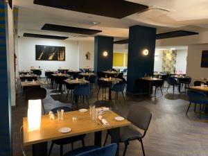 a restaurant with tables and chairs in a room at B&B HOTEL Chaumont in Chaumont