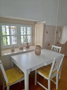 une cuisine avec une table blanche et deux chaises dans l'établissement Casa da Praia do Ribatejo - Casa da Arcada, à Praia do Ribatejo
