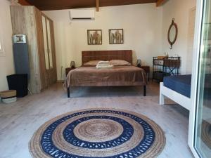a bedroom with a bed and a rug on the floor at Ktima Karamouzis in Petalidhion