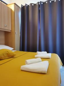 dos toallas blancas están sentadas en una cama amarilla en Apartment Jurčević, en Trogir