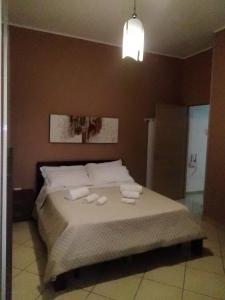 una camera da letto con un letto e asciugamani di Le Residenze D'Angelo 2 a San Prisco
