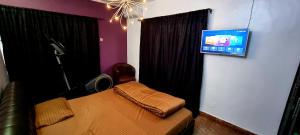 a room with a bed and a tv on a wall at Epic Homes in Ikeja