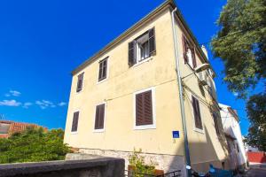 a yellow building with windows and a blue sky at Apartment Ena ,city center in Šibenik