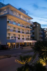 un gran edificio con una persona caminando delante de él en Hotel Benvenuto, en Caorle