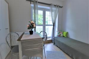 a room with a bed and a window with a table and chairs at Pensjonat Stary Busko Zdrój in Busko-Zdrój