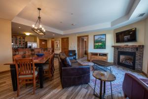 a living room with a table and a fireplace at Beautifully Renovated Two Bedroom Condo with a Balcony in Mountaineer Square condo in Crested Butte