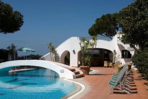 a swimming pool with chairs next to a building at Hotel Terme Villa Teresa in Forio d'Ischia