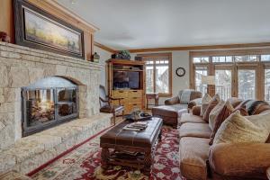 salon z dużym kamiennym kominkiem w obiekcie 4Br Ski in Ski Out the Top of Bachelor Gulch condo w mieście Avon