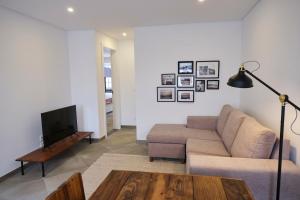 ein Wohnzimmer mit Sofa und Tisch in der Unterkunft Casas do Mercado - Casa Orion in Angra do Heroísmo