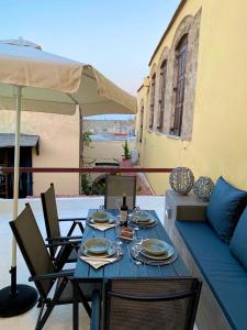 a table with plates and a bottle of wine on a patio at Rhodes Old Town Harmony Suite in Rhodes Town