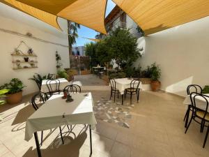 a patio with tables and chairs in a building at Apollon Hotel in Methana