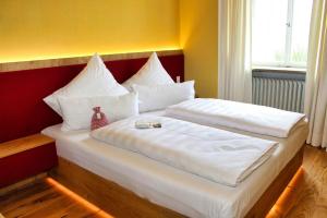 1 dormitorio con 2 camas y almohadas blancas en Schlosshotel Kirchberg, en Kirchberg an der Jagst