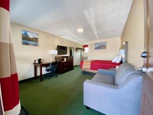 a hotel room with a bed and a couch and a desk at Colonial House Motor Inn in Perth