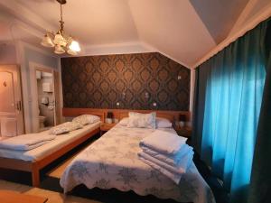 a bedroom with two beds and blue curtains at Motel Zoka in Dvorovi