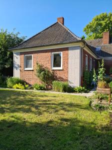 a brick house with a bench in the yard at Kleine Möwe Emden in Emden