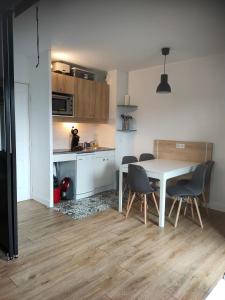 Risoul Appartement Rénové Piscine Balcons de Sirius في ريسول: مطبخ وغرفة طعام مع طاولة وكراسي