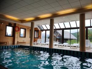 a swimming pool in a building with a large window at Risoul Appartement Rénové Piscine Balcons de Sirius in Risoul