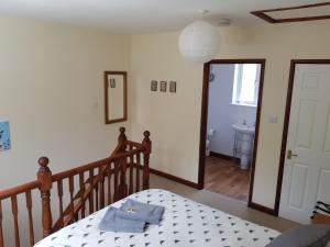 a bedroom with a bed and a staircase with a mirror at The Beehive - Self catering in the heart of the Forest of Dean in Whitecroft