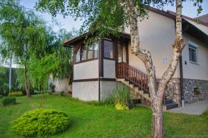 a house with a balcony and a tree at Apartment Rašće in Ogulin