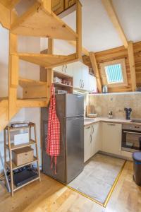Holiday home Mountain sight في زبلجك: مطبخ مع ثلاجة ستيل ستانلس وسقوف خشبية