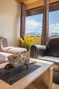een woonkamer met een salontafel met bloemen erop bij Holiday home Mountain sight in Žabljak
