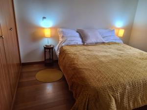 um quarto com uma cama e um candeeiro sobre uma mesa em Machico Comfort em Machico