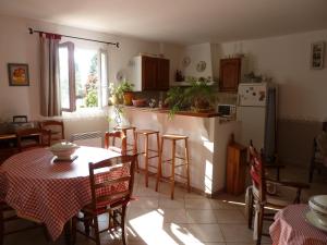 Saint-AndiolにあるLes Tournesolsのキッチン(テーブル、椅子、冷蔵庫付)