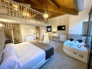 1 dormitorio con 1 cama grande y bañera en Akla Hotel Suites Valles Pasiegos, en Saro