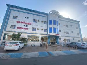 a large building with cars parked in front of it at منازل الرؤية الفندقية in Najran