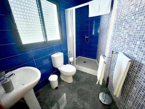 Un baño azul con inodoro y lavabo. en Casa Brisa do Mar, en Ponta Delgada 11 fotos más