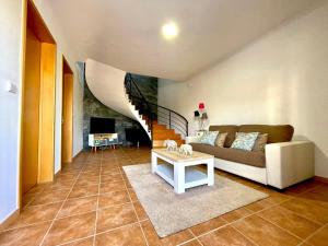 Una sala de estar con un sofá y una escalera. en Casa Brisa do Mar, en Ponta Delgada