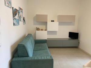 a living room with a green couch and a television at Appartamento Corallo in Sirmione