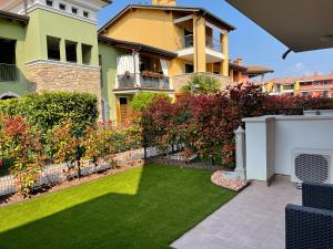 a yard with green grass in front of a house at Appartamento Corallo in Sirmione