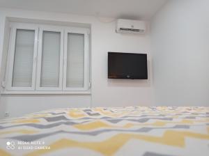 een slaapkamer met een bed en een flatscreen-tv bij Mars in Banja Luka