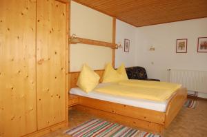 a bedroom with a bed with yellow sheets at Haus Beckenbauer in Sankt Michael im Lungau