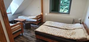 A bed or beds in a room at Fehérkőlápa Turistaház Panzió