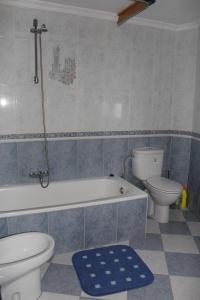 a bathroom with a toilet and a tub and a sink at Casa Sonrisa in Guaro