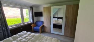 a bedroom with a bed and a chair and a window at Lichtblick in Wangerland