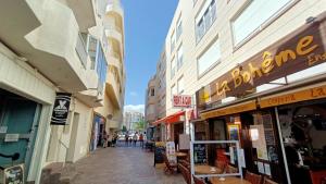 a street with shops and people walking down a street at alquilaencanarias Tio Claudio Beach in El Médano