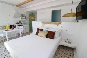 a bedroom with a white bed with pillows at Vino suites in Agia Anna Naxos +57 photos